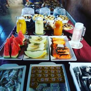 uma mesa coberta com pratos de alimentos e bebidas em Pousada Raio de Luz em Pirenópolis