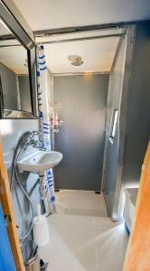 La salle de bains est pourvue d'une douche et d'un lavabo. dans l'établissement Maggie May House Boat - Colchester - 5km from Elephant Park, à Colchester