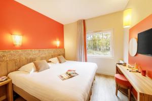 
a hotel room with a bed and a television at Center Parcs Le Bois aux Daims in Morton
