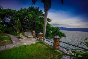 a table and chairs sitting on a path next to the water at Romlan in Tuk Tuk