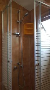 La salle de bains est pourvue d'une douche et d'une porte en verre. dans l'établissement La Casa in Piazza, à Gubbio