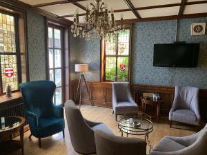 a living room with chairs and a flat screen tv at Hotel Landhaus Höpen in Schneverdingen