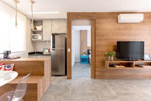 a living room with a television and a kitchen at Casa Del Mar in Rio de Janeiro