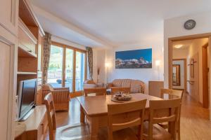 a living room with a table and chairs and a television at Monte Cervino Apartment AS21 in Breuil-Cervinia