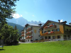 a large building with balconies on the side of it at Hotel Edelweiss in Val di Zoldo