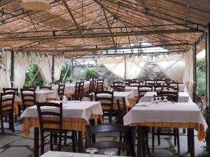 StazzemaにあるLa Paniaのテーブルと椅子(白いテーブルクロス付)が備わるレストラン