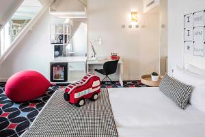 
a red and white teddy bear sitting on top of a white couch at Hotel Joke - Astotel in Paris
