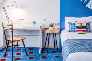 a bedroom with a desk and a bed with blue walls at Hotel Joke - Astotel in Paris