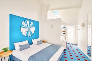 a blue and white bedroom with a bed with a clock on the wall at Hotel Joke - Astotel in Paris