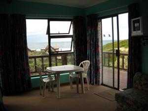 una mesa y sillas en una habitación con vistas al océano en Sandown Self-Catering en Cape St Francis