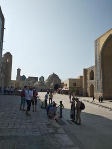 un grupo de personas de pie frente a una mezquita en ZARIN Guest House B&B, en Bukhara