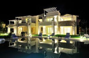 a large white house with a swimming pool at night at Villa Onofria in Sirmione