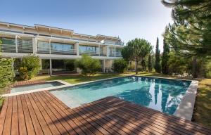 a swimming pool in front of a house at Troia Residence by The Editory - Beach Houses in Troia