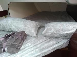 an unmade bed with two pillows and a blanket at Inolvidable experiencia en un velero de 11 metros! in Zumaia