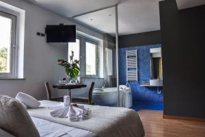 a room with two beds and a bathroom with a tub at Aston Hotel in Pino Torinese