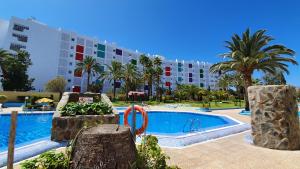 a swimming pool in front of a large building at Atlantic Coast Apartment - Playa Del Inglés in Playa del Ingles