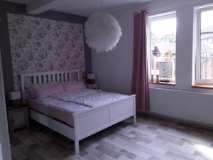 a bedroom with a white bed and a window at Ferienhaus Landliebe Liebenstein in Liebenstein