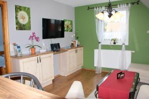 ein Wohnzimmer mit einem Flachbild-TV und einem Tisch in der Unterkunft Ferienwohnung Morgensonne in Prerow