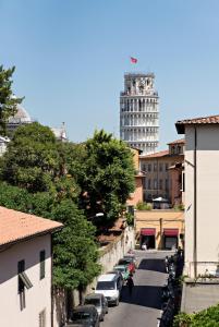 a city street with a tall tower and cars parked at LH-Casa Dora in Pisa