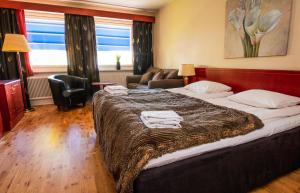 a hotel room with a large bed and a living room at Skoogs City BnB in Piteå