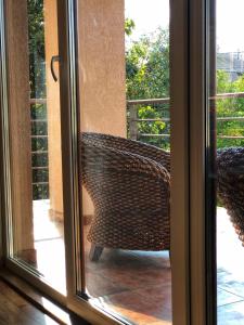 una sedia di vimini seduta su un portico con vista attraverso una finestra di Deluxe Old Ungvar Apartments a Užhorod