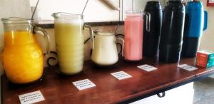 four glass vases filled with different types of juice at Pousada Pouso Alto in Pouso Alto