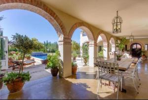 an indoor patio with a table and chairs and a pool at Sandmartins in Suider-Paarl