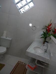 baño con lavabo y aseo y ventana en Recanto Solar da Paz, en Isla de Boipeba