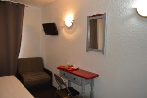 a room with a table and a mirror and a chair at Hotel Panda in Pas de la Casa