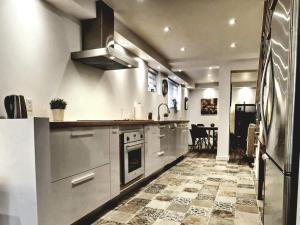 cocina con electrodomésticos de acero inoxidable y suelo de baldosa en Cosy apartment at Bossuet road en Montreal