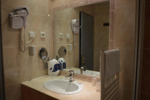 a bathroom with a sink with a phone and a mirror at Hotel Panda in Pas de la Casa