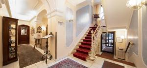 a staircase in a house with a red rug at Romantik Hotel Fürstenhof in Landshut