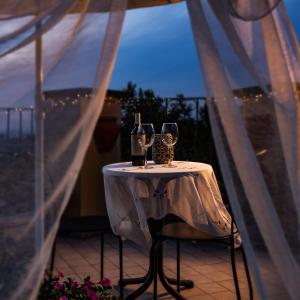 un tavolo con 2 bicchieri da vino sul balcone di B&B Buonfiglio Cicconcelli - Terrazza panoramica a Frascati