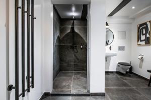 baño con ducha a ras de suelo junto a un lavabo en The Churchill Penthouse by Daniel&Jacob's, en Copenhague
