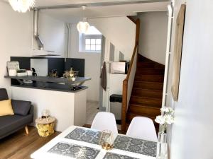 a living room with a table and chairs and a staircase at L’Heure Bleue in Le Crotoy
