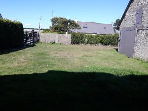 un patio con una valla y un edificio en LE PIGEONNIER UTAH BEACH, en Sainte-Marie-du-Mont