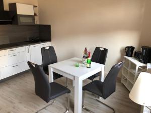 a white table and black chairs in a kitchen at Ferienwohnung Harzerfuchs in Wernigerode