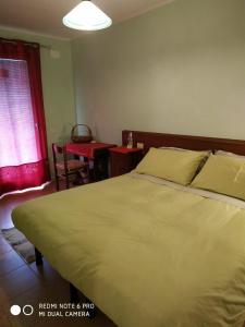 a bedroom with a large bed and a table at Agriturismo Il Girasole in Feltre