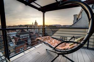 una sedia su un balcone con vista sulla città di Budapest Harmony Apartments a Budapest