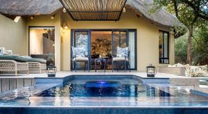 a swimming pool in front of a house at Kings Camp in Timbavati Game Reserve