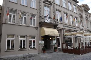 un bâtiment avec des drapeaux sur son côté dans l'établissement Hotel De Zalm, à Audenarde