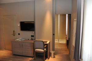 a room with a desk and a chair and a television at Hotel De Zalm in Oudenaarde