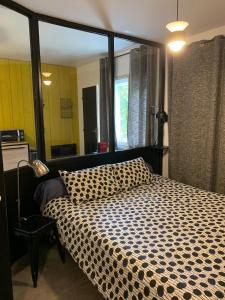 ein Schlafzimmer mit einem großen Bett mit einer karierten Decke in der Unterkunft L'Atelier in Le Mans