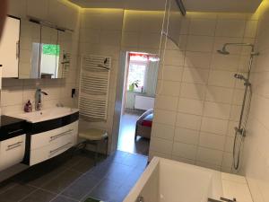 Un baño con bañera, lavabo y ducha. en Ferienwohnung Harzerfuchs, en Wernigerode
