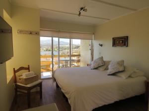 um quarto com uma cama grande e uma varanda em Riomar Apart Hotel em Concón