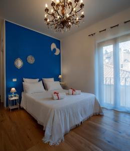 um quarto com uma grande cama branca e uma parede azul em B&B Buonfiglio Cicconcelli - Terrazza panoramica em Frascati