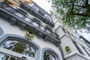 un bâtiment blanc avec des panneaux sur son côté dans l'établissement B&B HOTEL Brussels Centre Gare du Midi, à Bruxelles