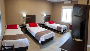 Habitación de hotel con 3 camas con almohadas rojas en Samay Hotel Boutique, en Colonia Dora