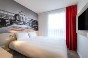 a bedroom with a bed and a painting on the wall at B&B HOTEL Brussels Centre Gare du Midi in Brussels