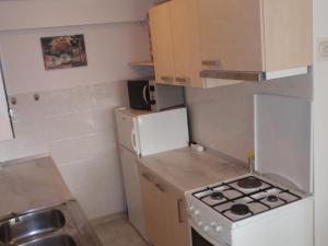 małą kuchnię z kuchenką i lodówką w obiekcie Apartments Maximir w Zagrzebiu